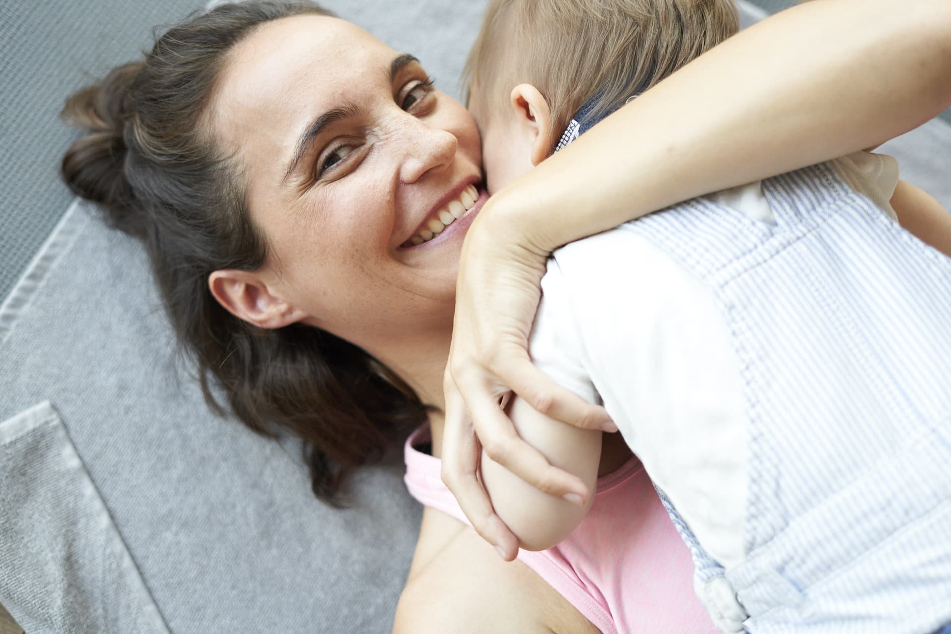 Happy mother with her baby in her arms at Mother & Child class at gym