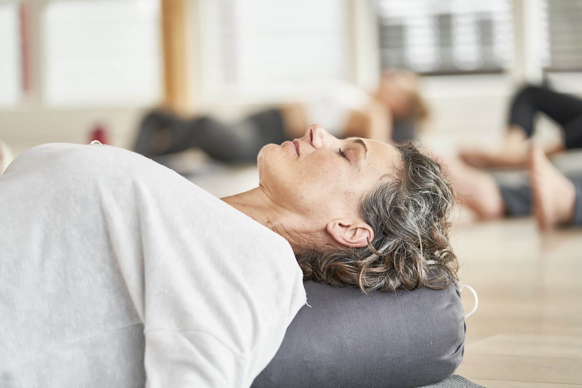 Eine Frau bei der Entspannung im Body & Mind Kurs