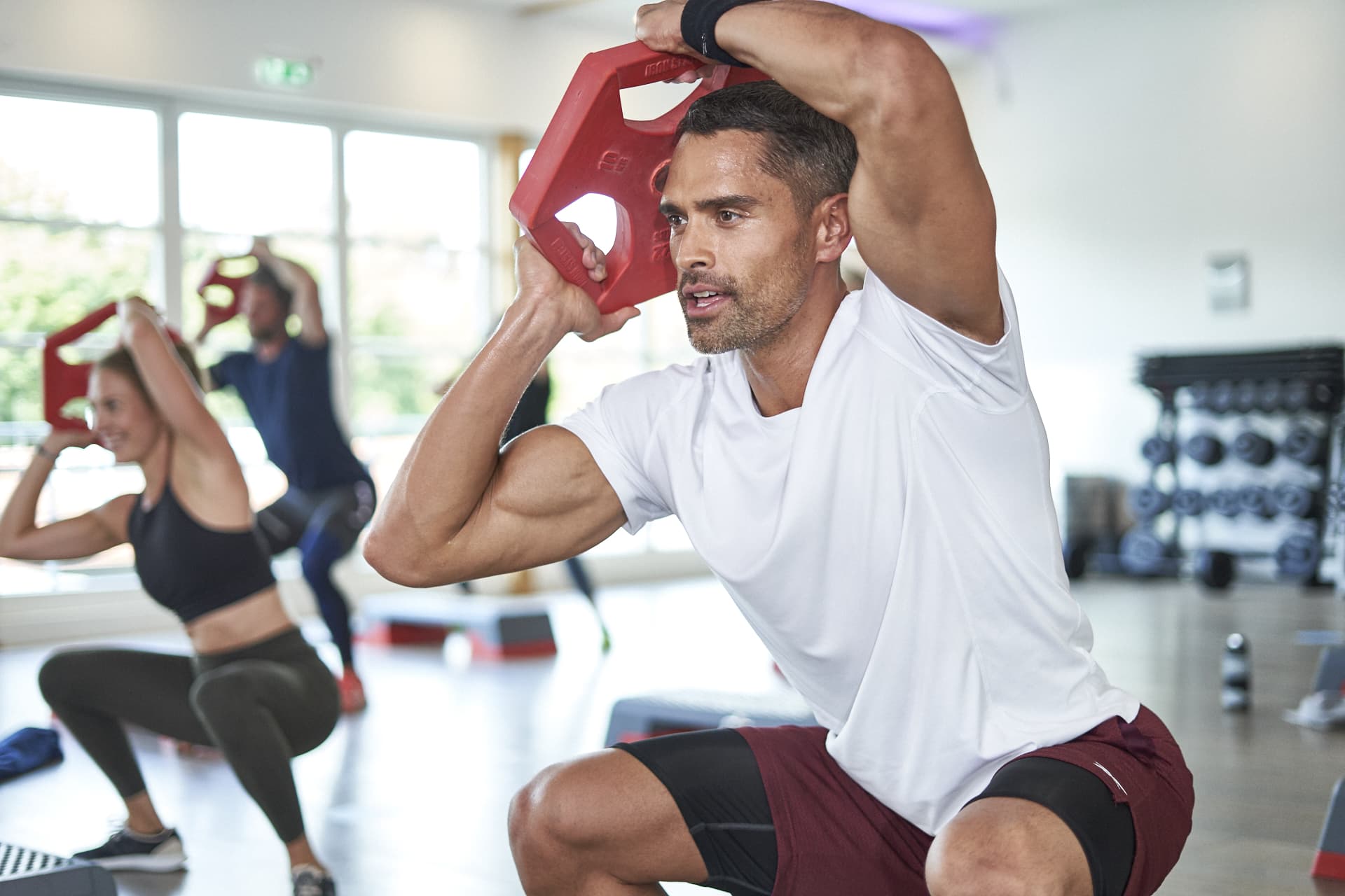 Ein Mann beim Training mit einer Hantel im Kursraum