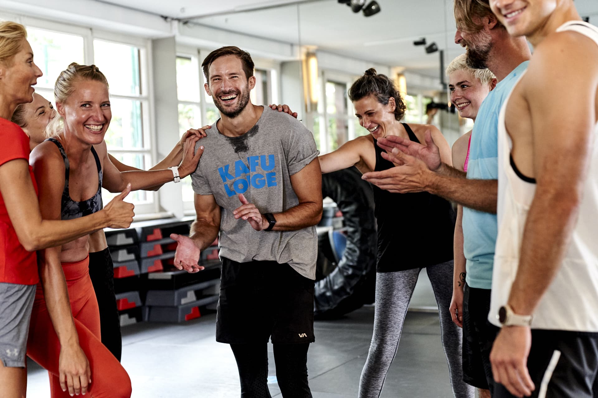 Eine Gruppe von Menschen steht nach dem Sport in einem Kreis und lacht