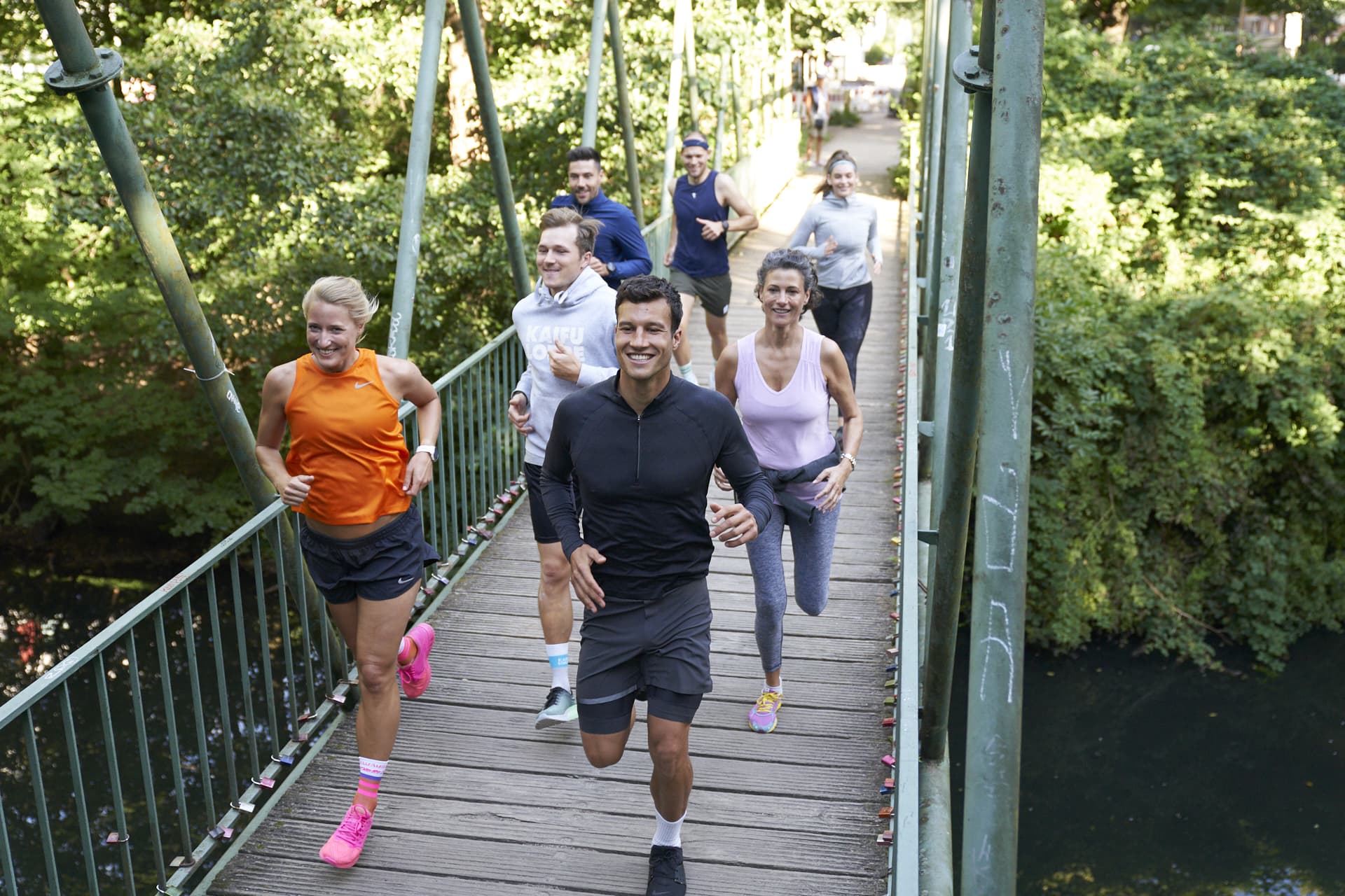 Eine Gruppe Läufer*innen beim Lauftraining auf einer Brücke