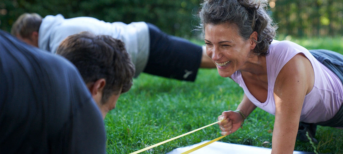 Woman in sportswear on meadow doing outdoor workout