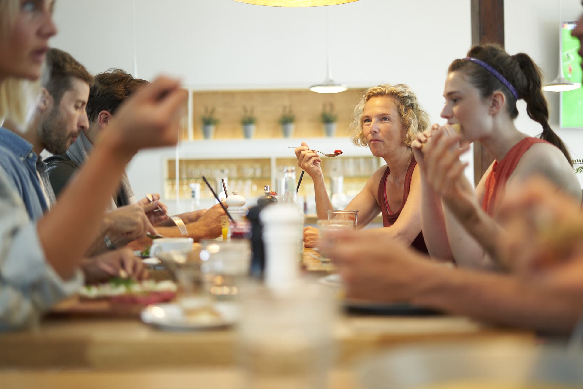 Eine Gruppe von Mitgliedern beim gemeinsamen Essen in einem Restaurant eines Fitnessstudios