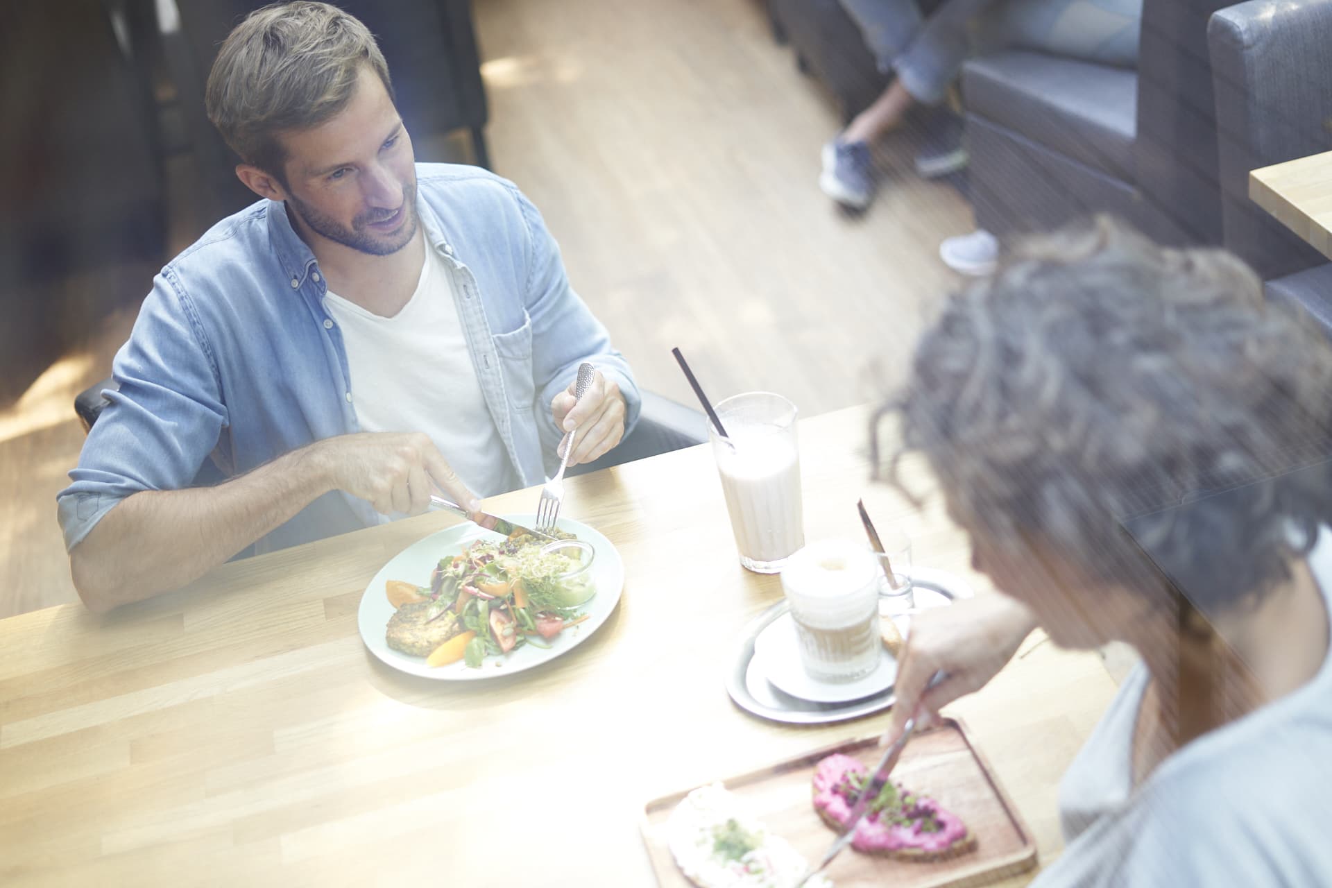 A woman and a man at a table eating in a gym restaurant