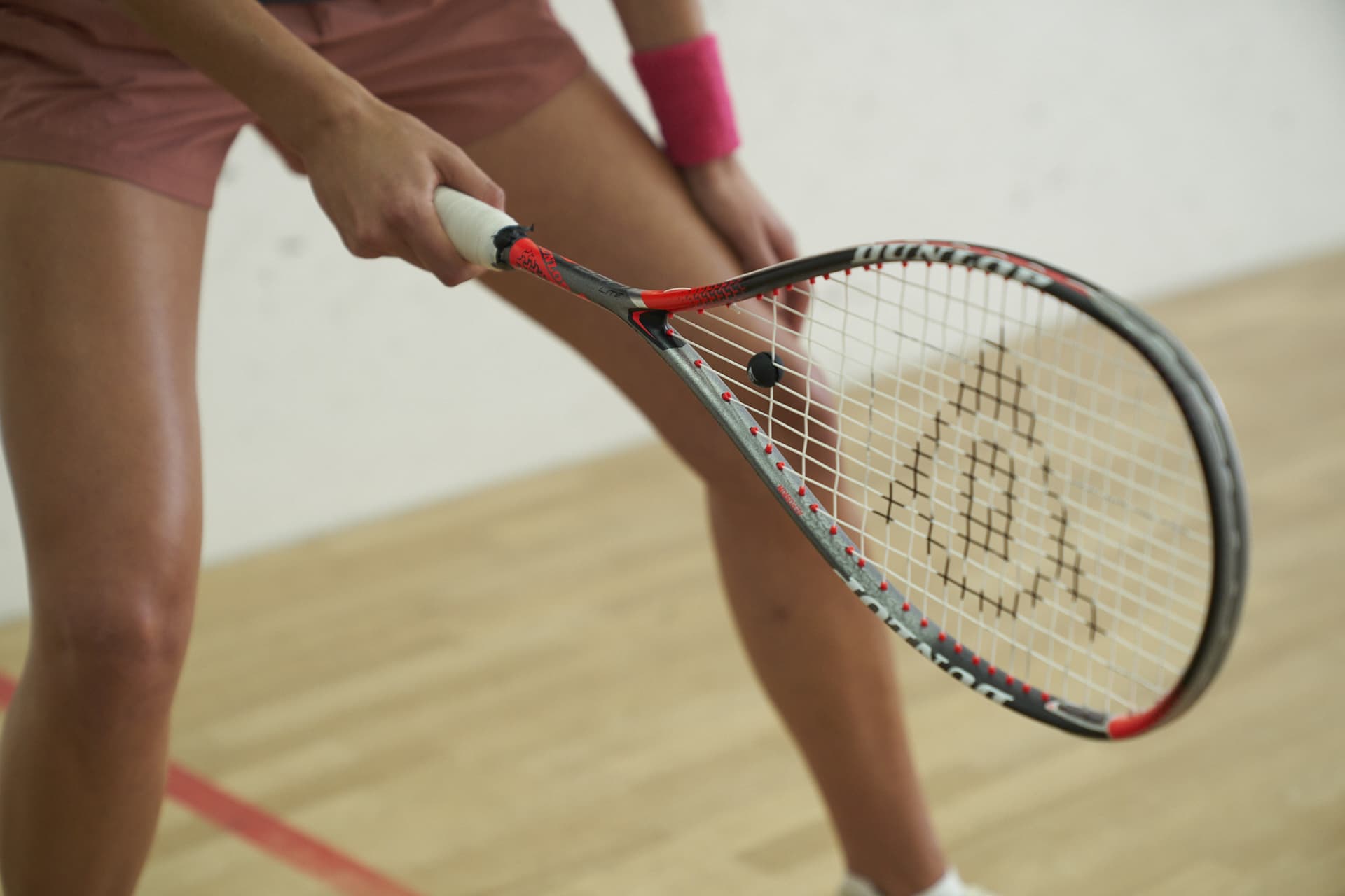 a woman holding a squash racket in her hand