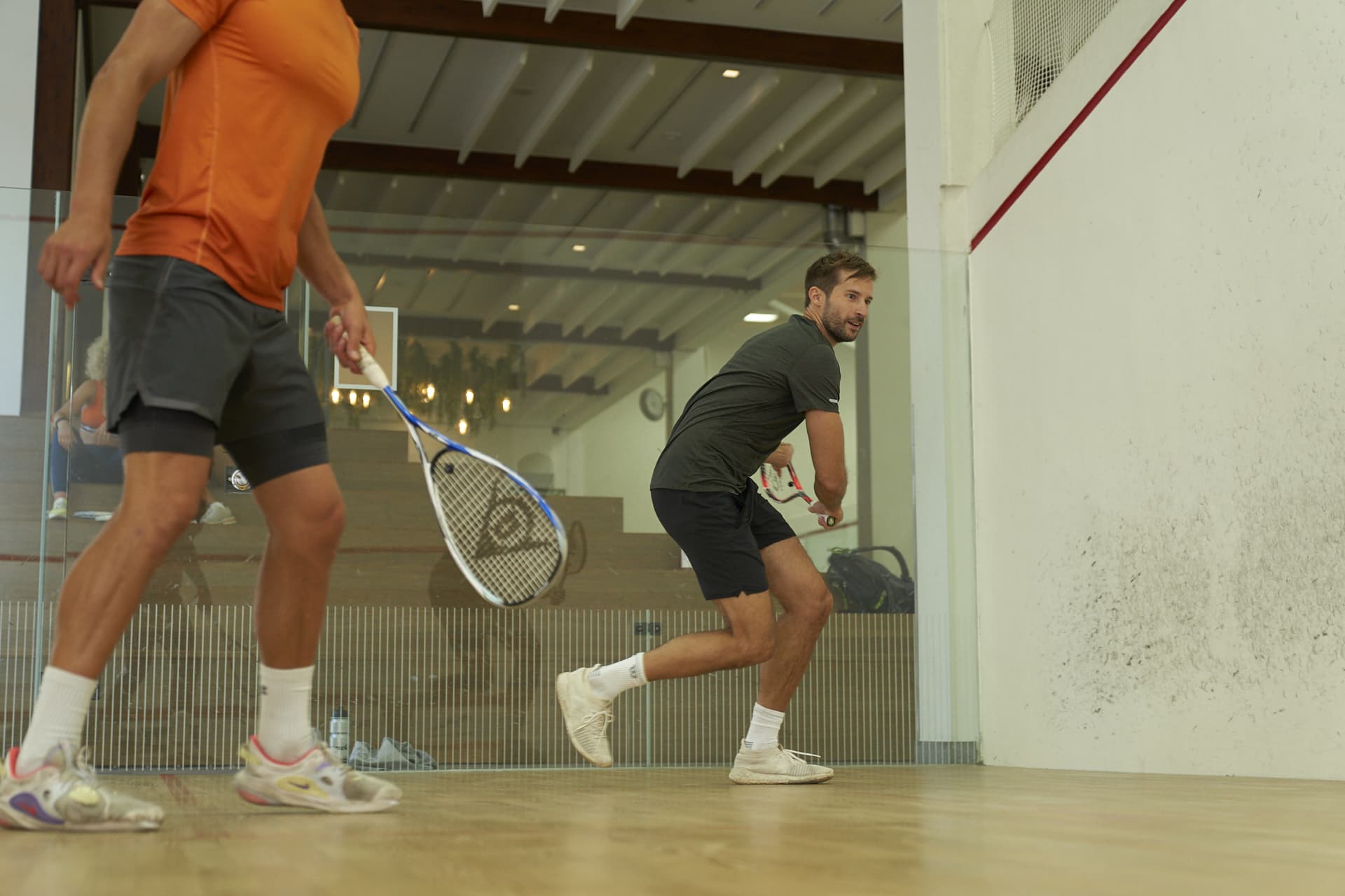 two men playing squash in the gym